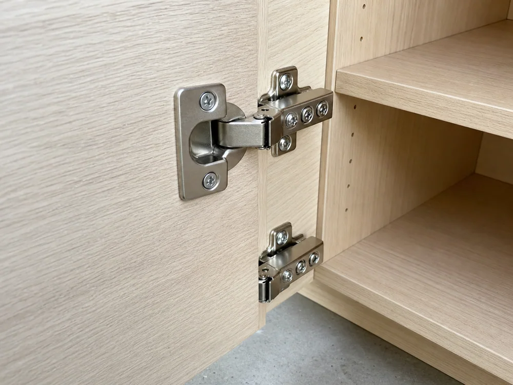 A concealed cup hinge fitted inside a frameless cabinet.